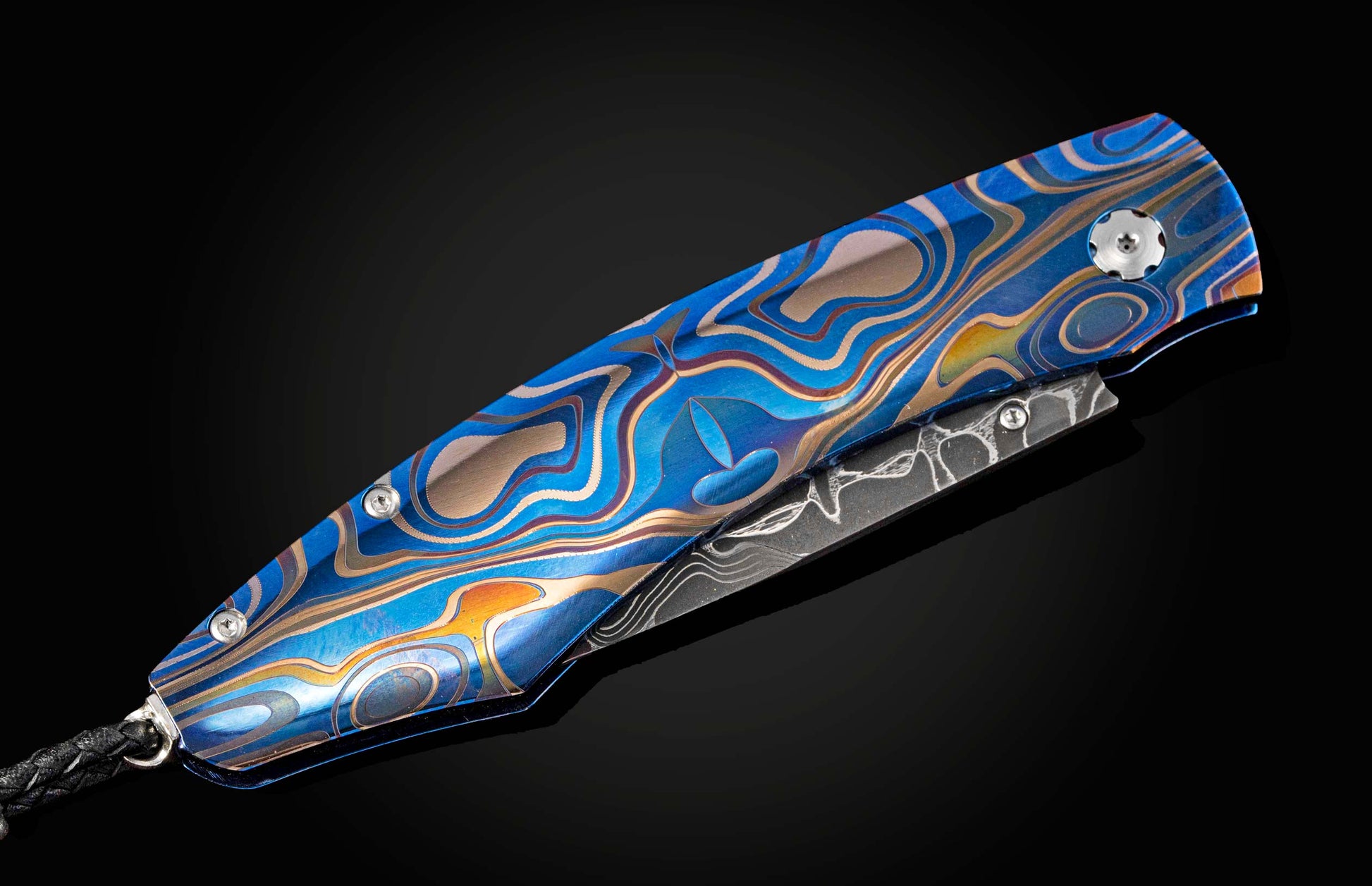 Folding knife with a blue and silver patterned handle on a black background