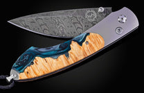 William Henry knife with a damascus steel blade and shockwood handle on a black background