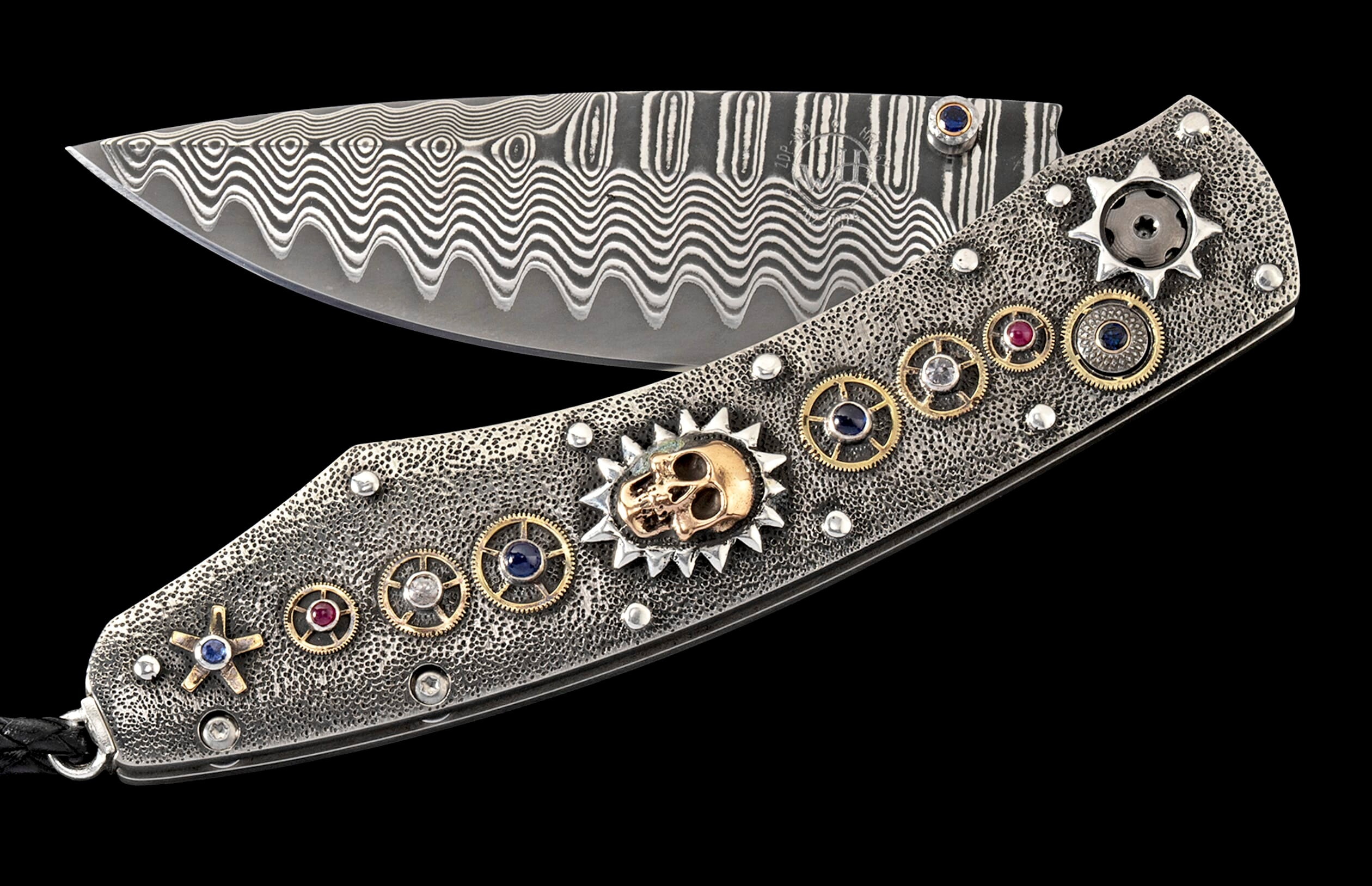 Ornate folding knife with wavy Damascus blade and textured metal handle featuring a gold skull, gears, and multi-colored gems.