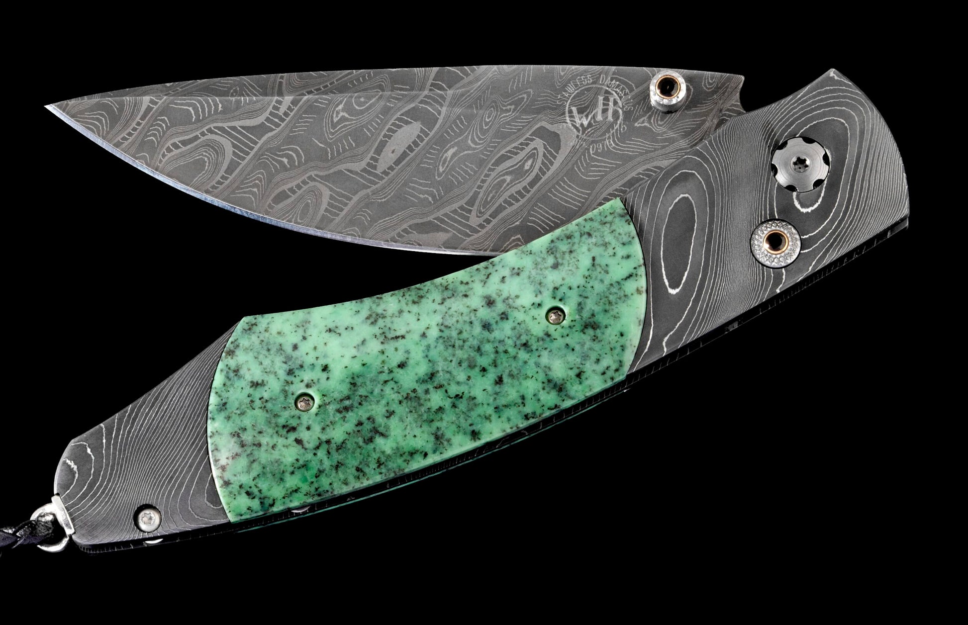 Folding knife with wavy Damascus steel blade and handle, a speckled green jade inlay, and polished metal hardware.