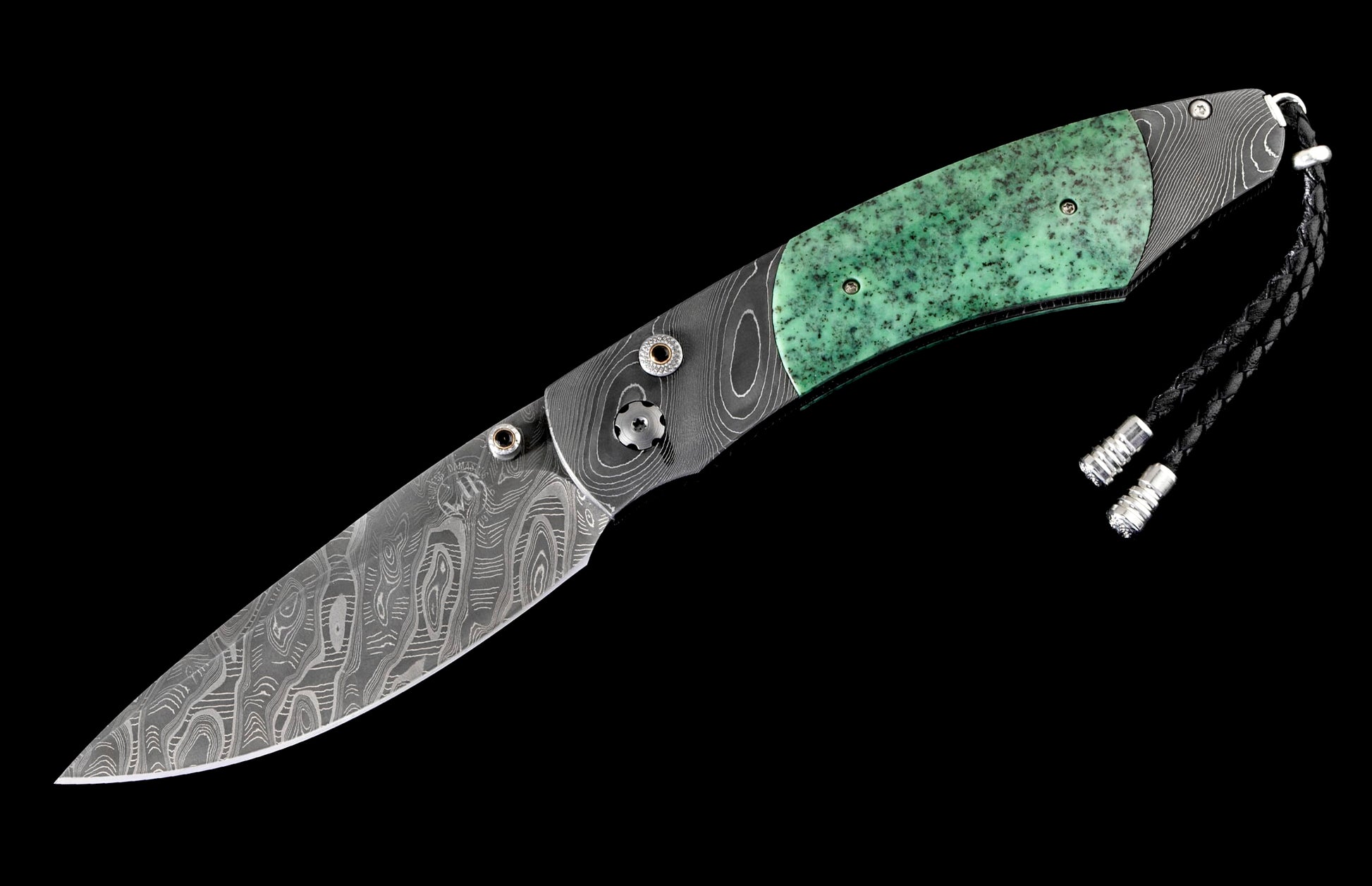Folding knife with a Damascus steel blade, speckled green handle, and black braided leather lanyard.