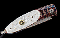 Decorative knife with an iridescent mother-of-pearl handle, wavy multi-colored scales, a gold accent, and a black lanyard.