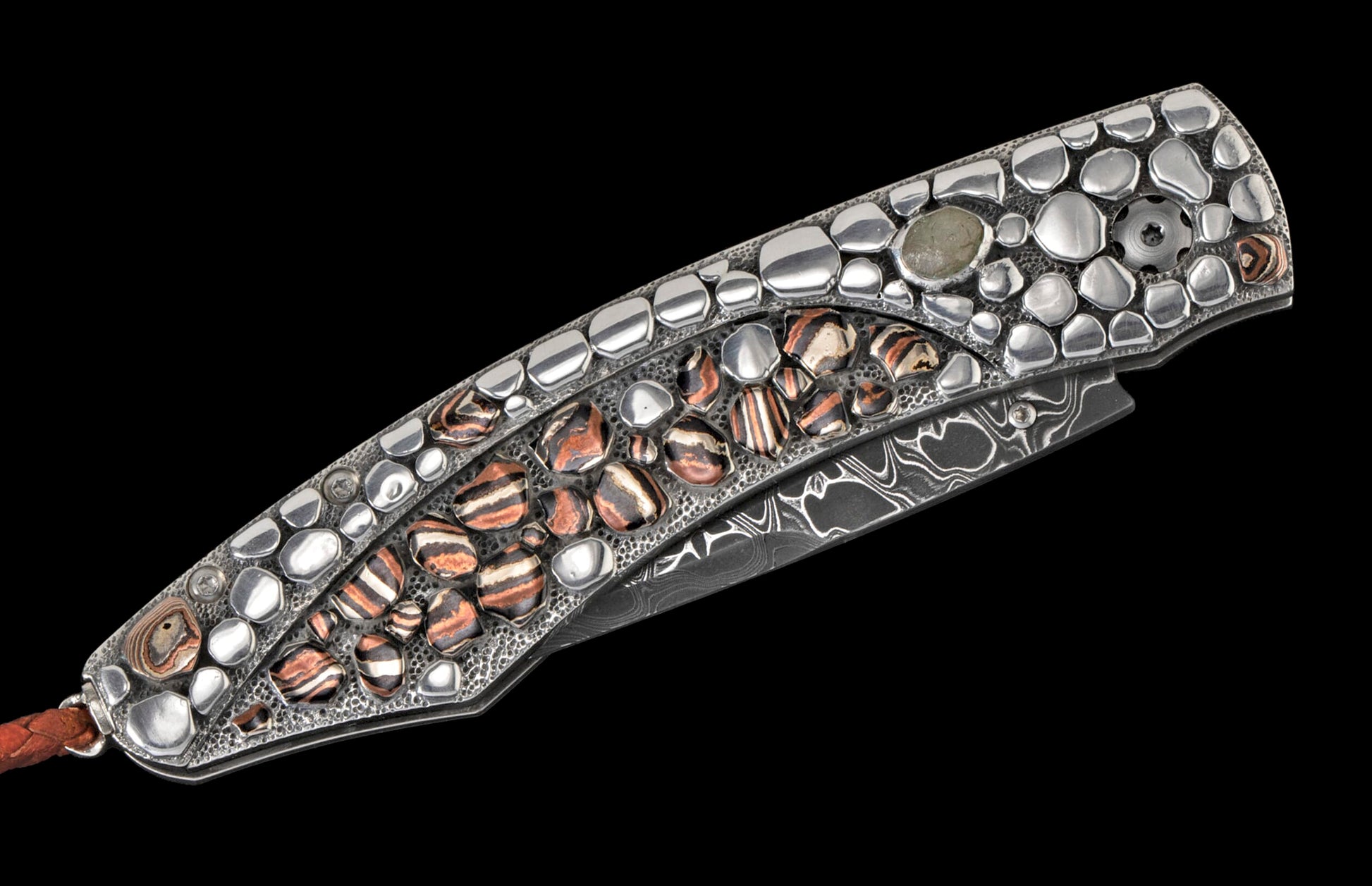 Decorative folding knife handle with polished silver-colored and striped brown-black inlays on a textured background, with a Damascus blade and a leather lanyard.
