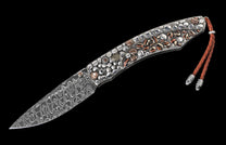 Artistic folding knife with a Damascus steel blade and a mosaic handle of polished silver and striped stone pieces, with a brown leather lanyard.