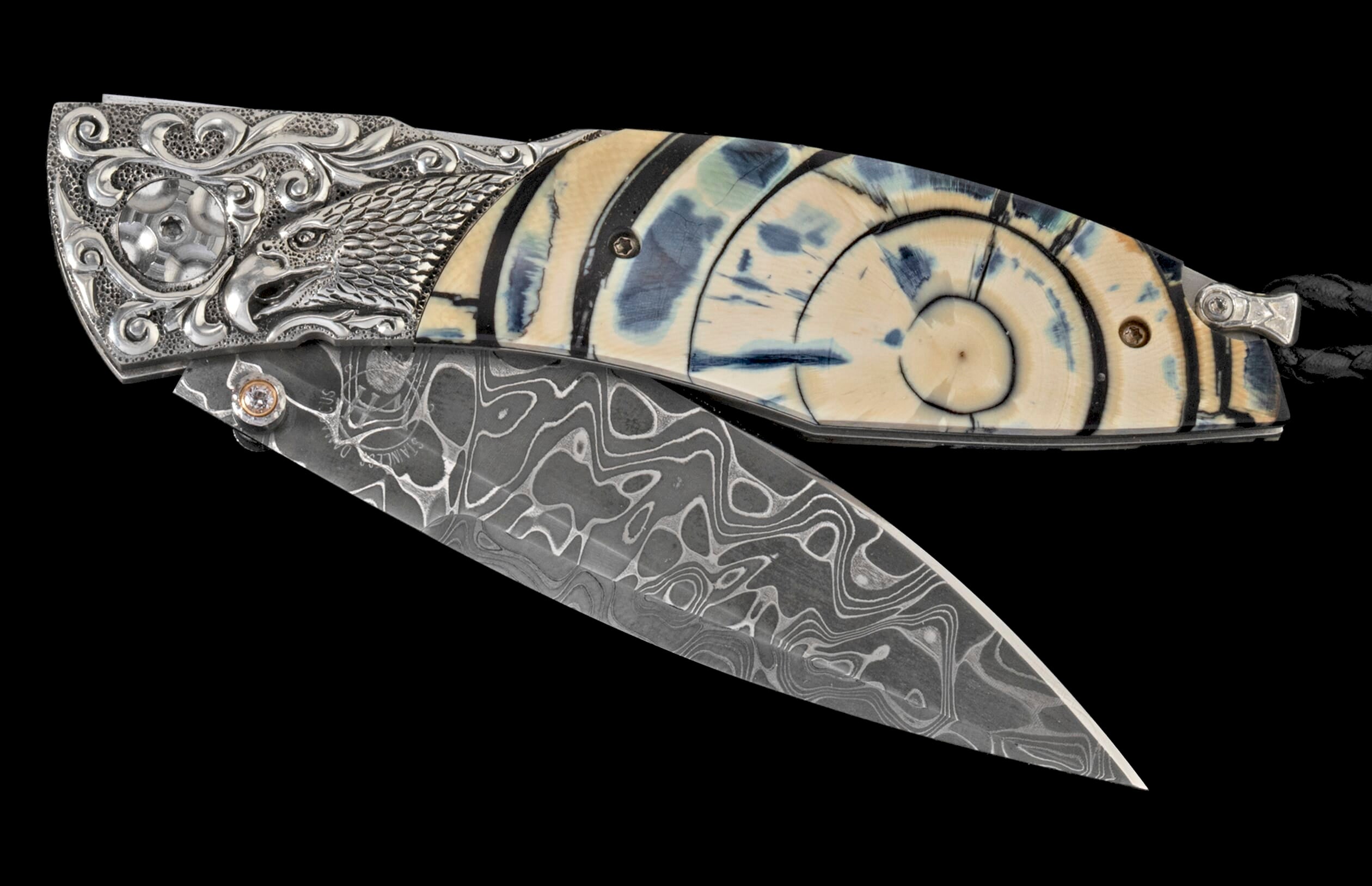 Ornate folding knife with an engraved silver eagle head bolster, blue-veined ivory handle with concentric rings, and patterned Damascus steel blade.
