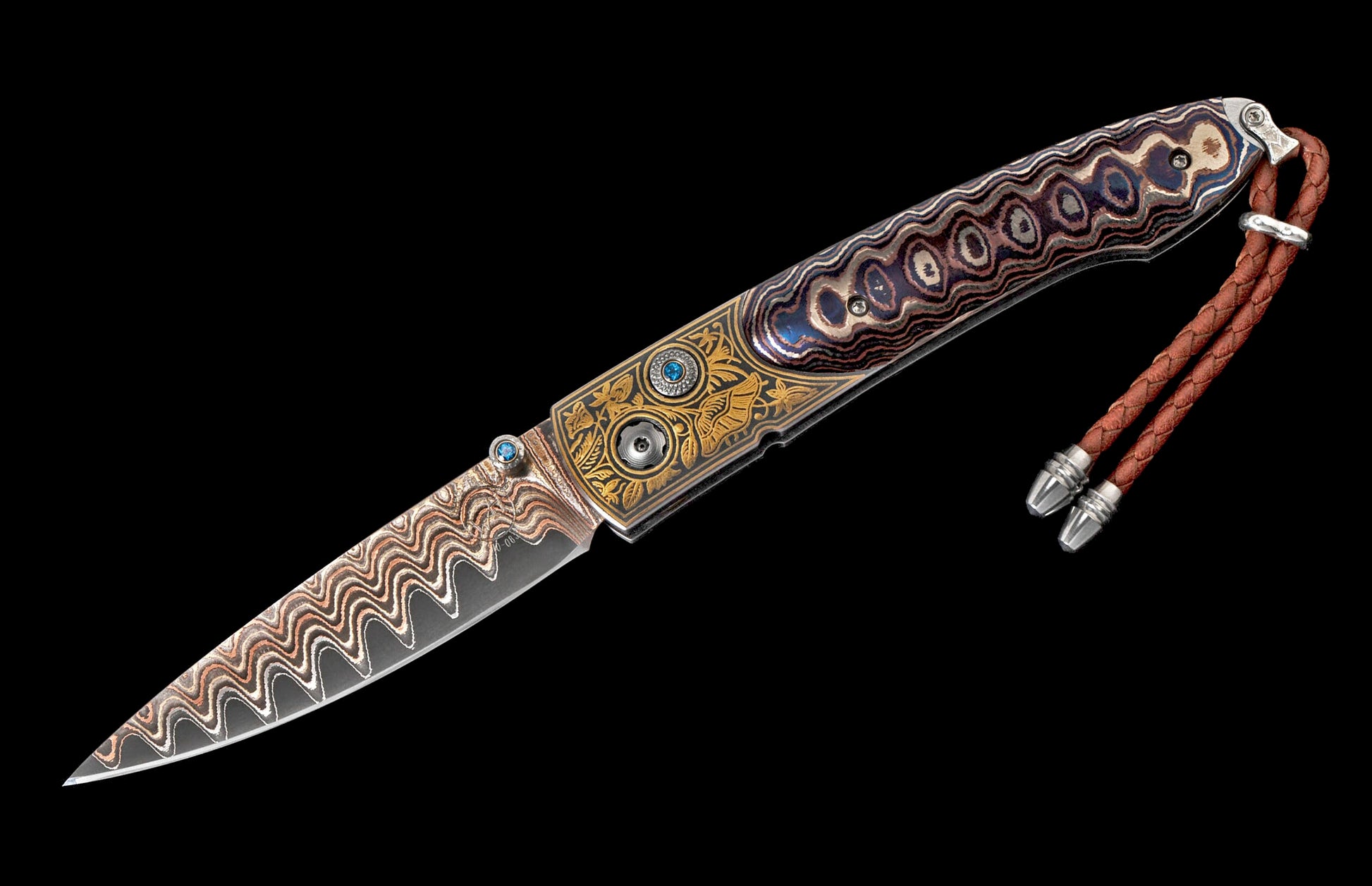 Ornate folding knife with wavy Damascus blade, gold floral engraved bolsters, two blue gemstones, and multicolored patterned handle scales, with a braided leather lanyard.