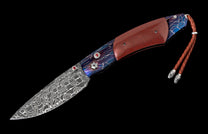 Folding knife with a Damascus steel blade, reddish-brown wood and blue lightning-patterned handle, accented with red gems and a leather lanyard.