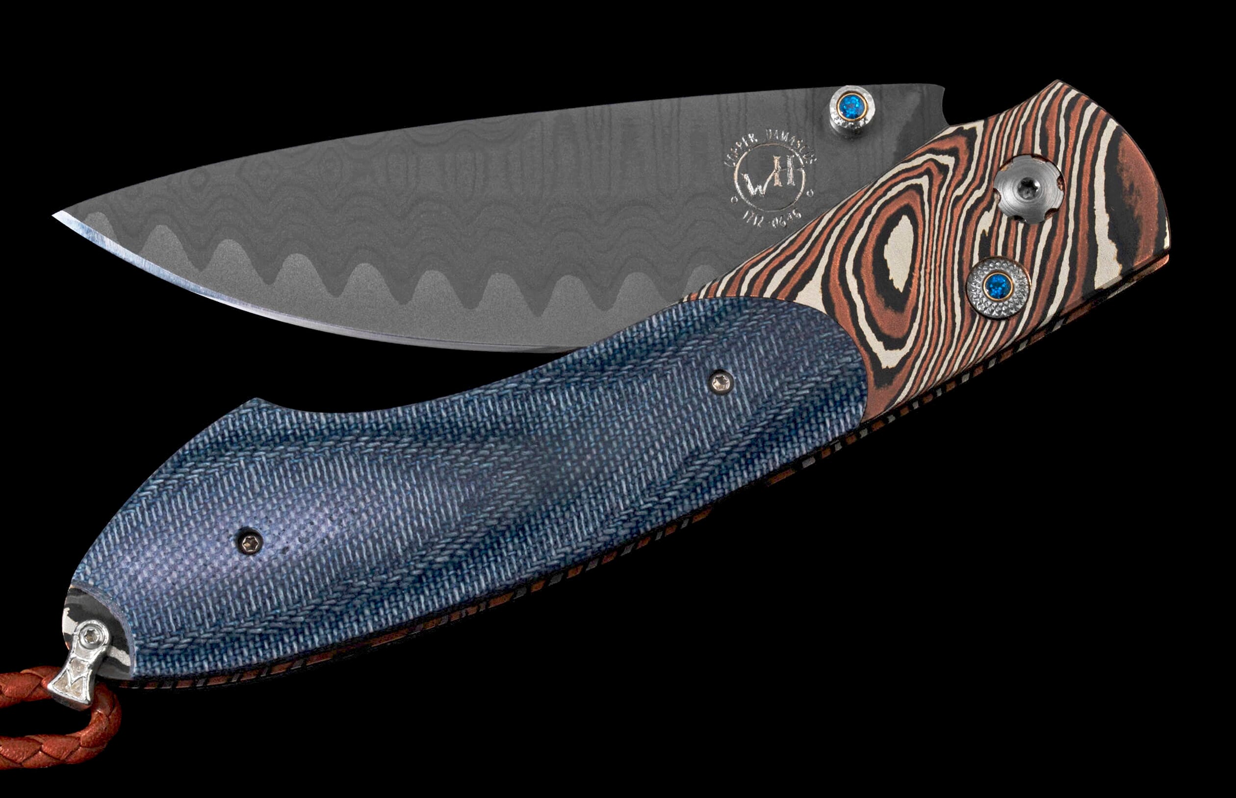 Folding knife with dark gray wavy Damascus blade and blue textured handle with brown swirled accents, "WIENER DAMASCUS" mark, blue gemstones, and leather lanyard.