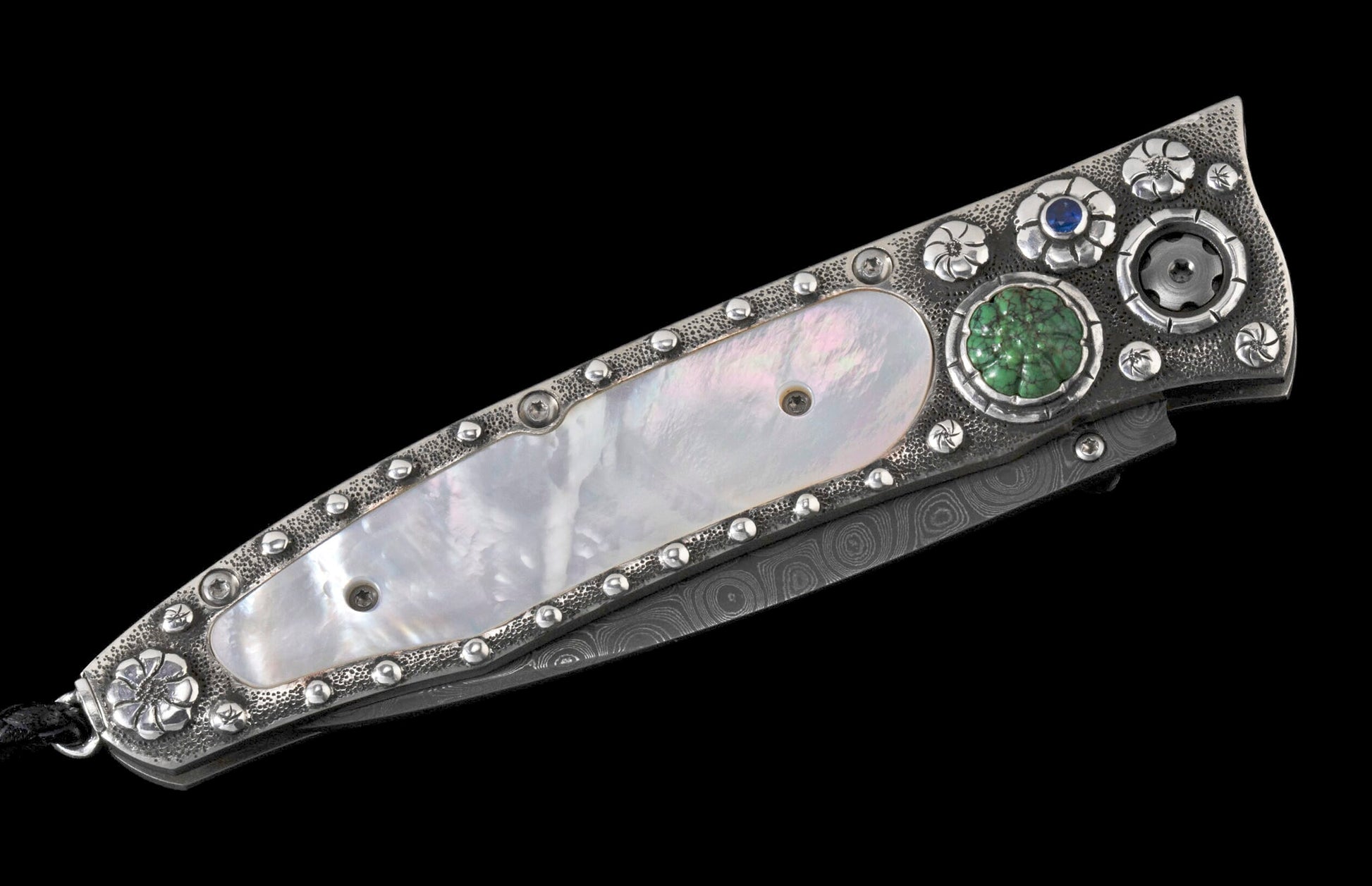 Decorated folding knife with a mother-of-pearl handle inlay, textured silver details, green and blue gemstones, and a Damascus blade.