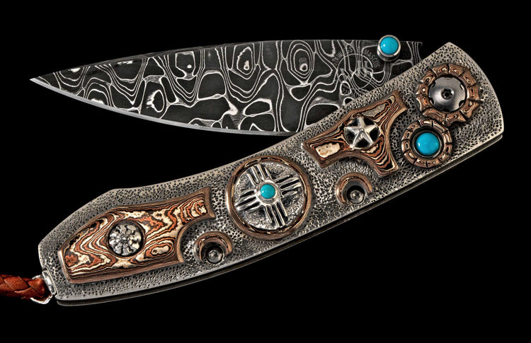 Decorative folding knife with Damascus blade, textured silver handle, turquoise inlays, patterned copper elements, and a brown leather lanyard.