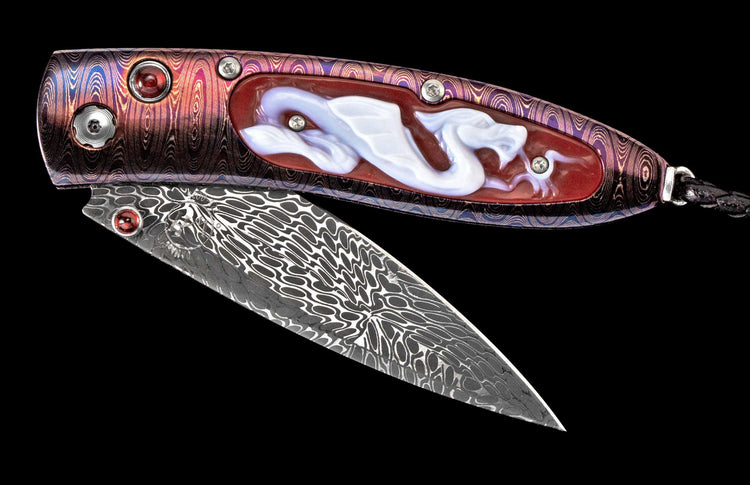 Ornate folding knife with a purple and red patterned handle featuring a sculpted white dragon, a Damascus blade, and red gemstone accents.