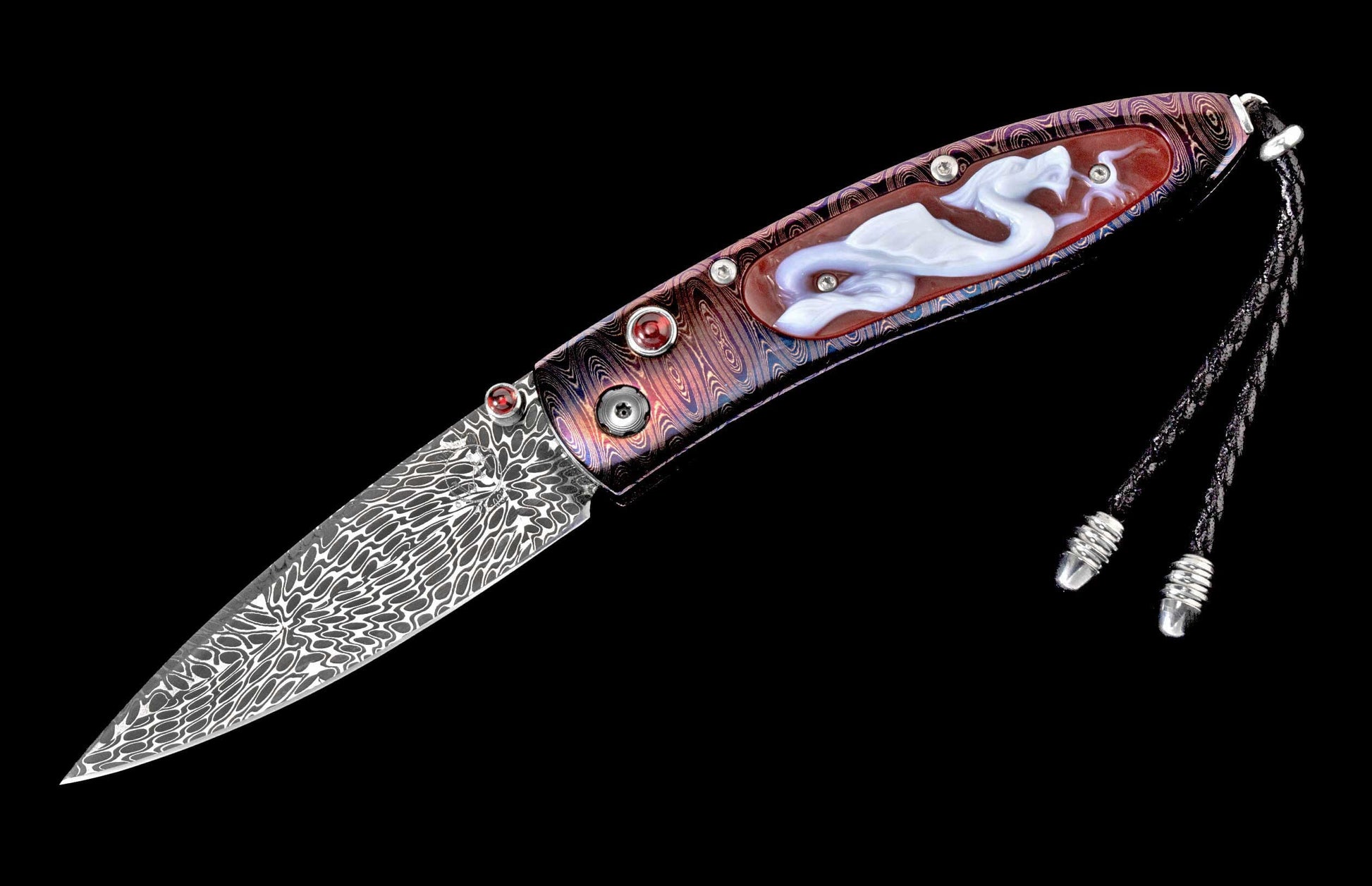 Ornate folding knife with a wavy Damascus steel blade, iridescent handle featuring a white dragon inlay, red accent gems, and a braided lanyard.