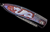 Close-up of an ornate knife handle featuring vibrant blue and purple Damascus steel with a carved white dragon inlay on a reddish-brown base.