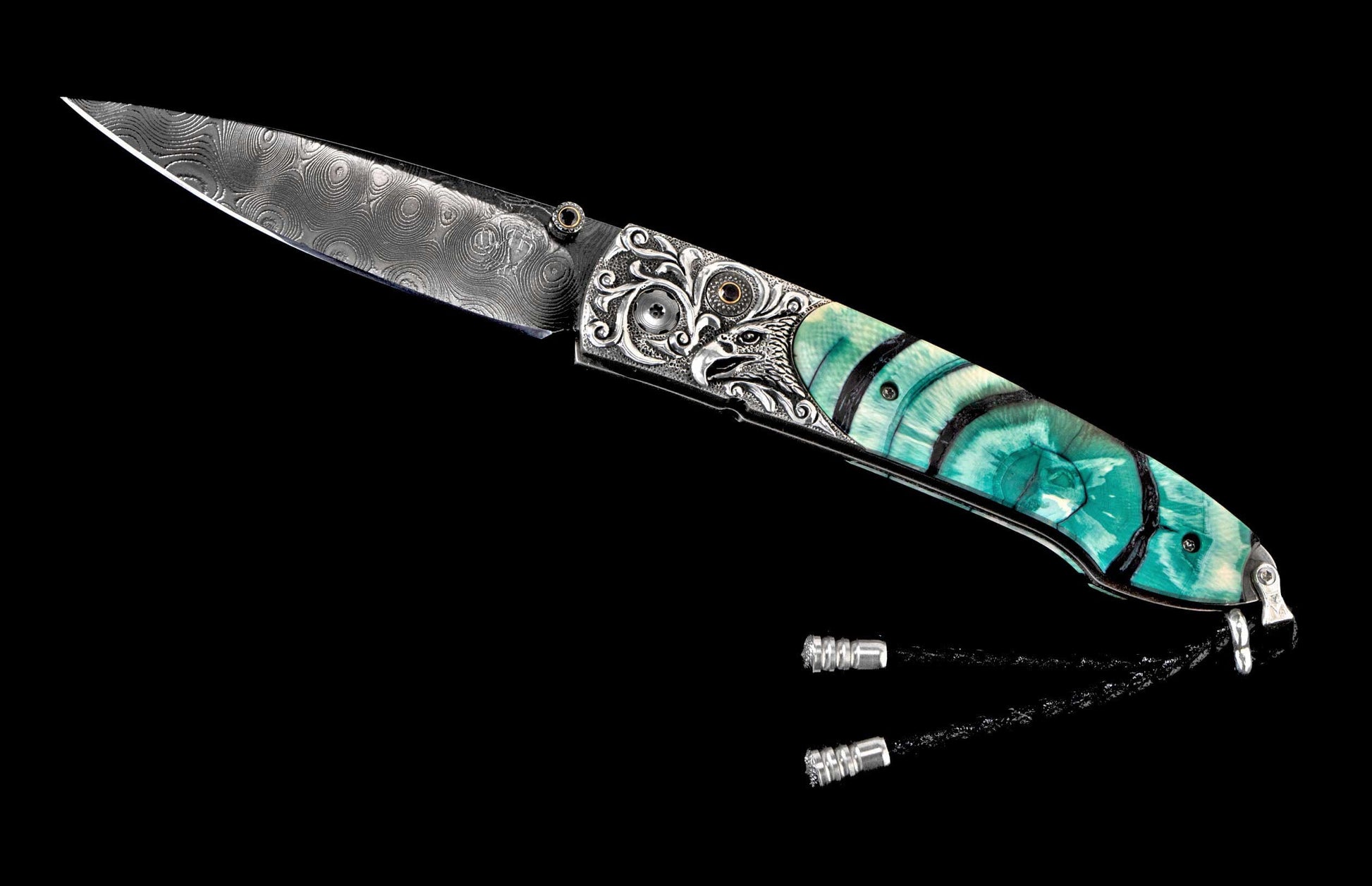 Ornate folding knife with Damascus blade, silver engraved eagle bolster, teal veined handle with black bands, and a braided lanyard.