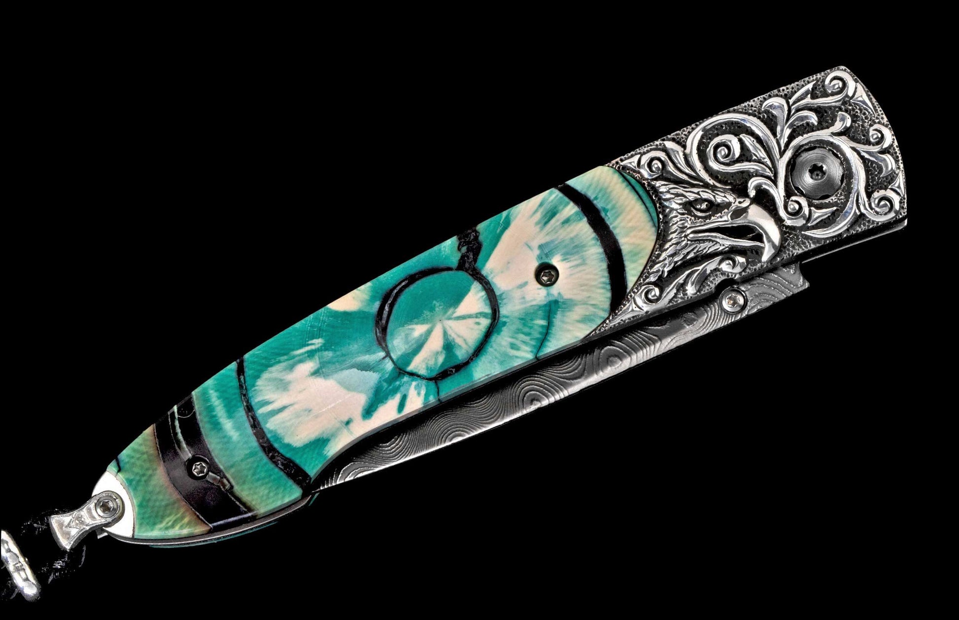 Ornate folding knife with turquoise and white marbled handle, silver Damascus blade, and eagle head carved bolster.