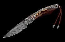Ornate folding knife with a Damascus steel blade, brown wood handle, silver detailing featuring a golden dragon, and a braided leather lanyard.