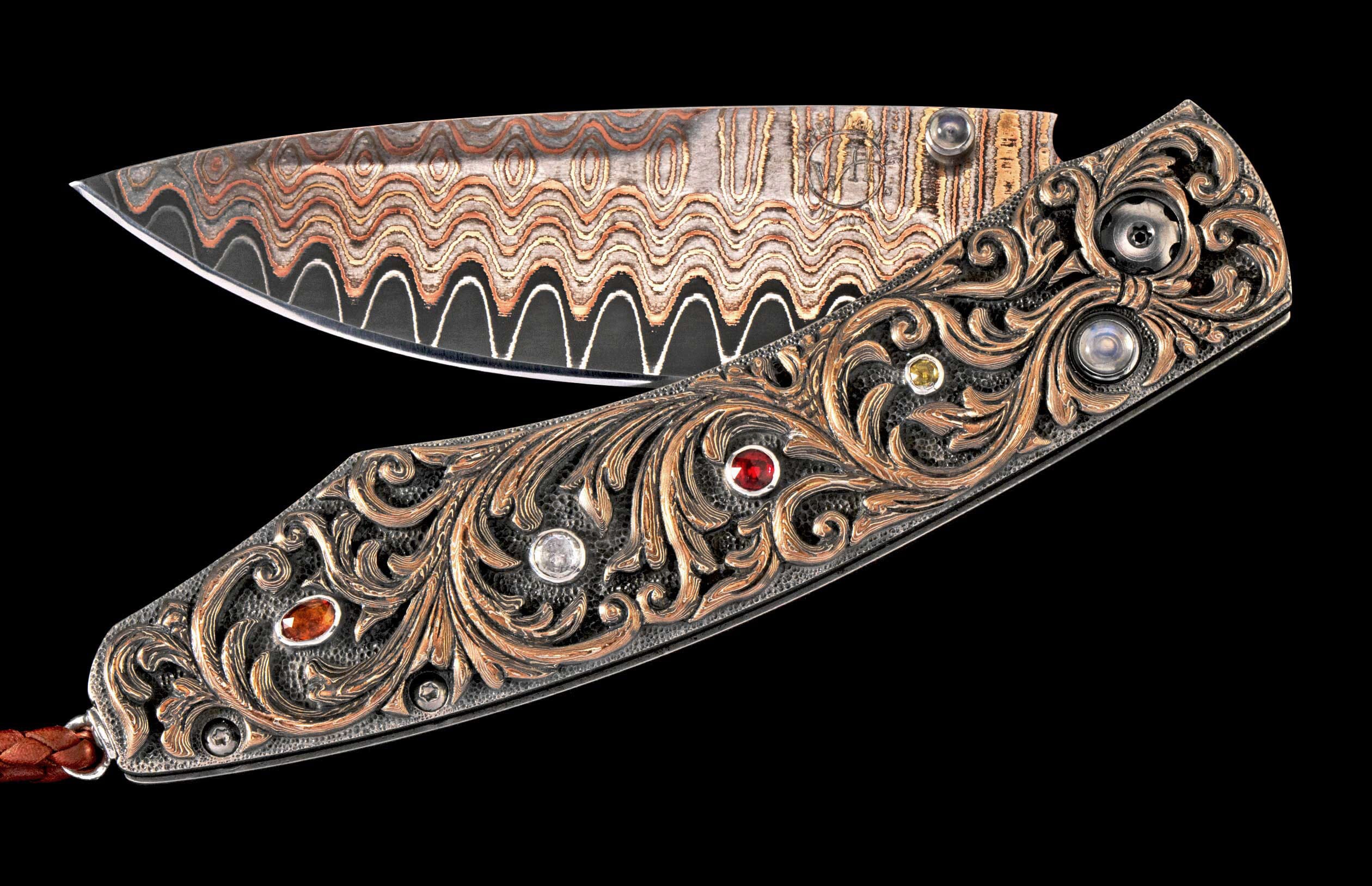 Folding knife with wavy copper Damascus blade and engraved metal handle adorned with colorful gemstones.