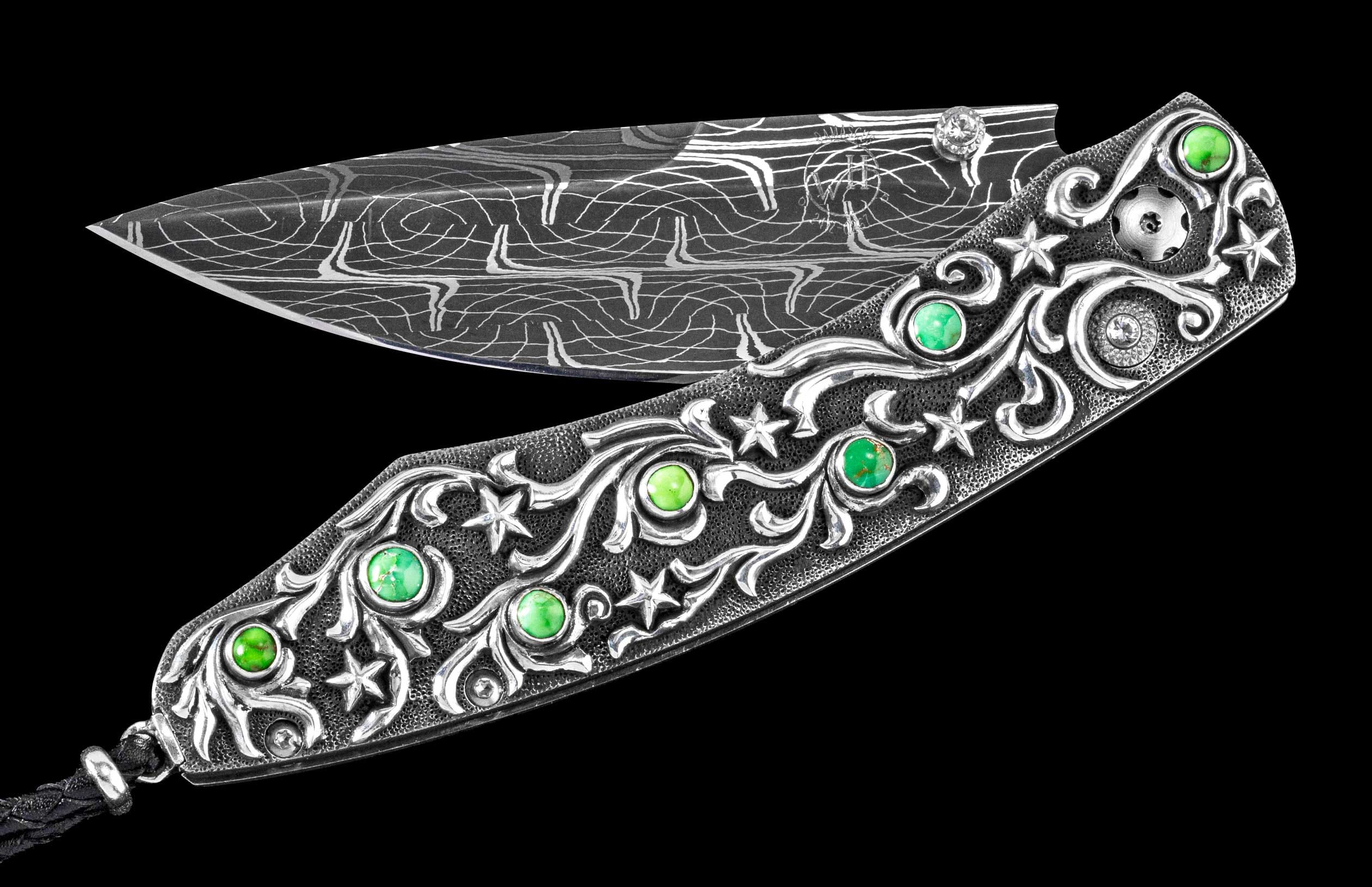Ornate folding knife with a Damascus blade and silver-colored handle featuring scrollwork, stars, green gemstones, and a black cord.