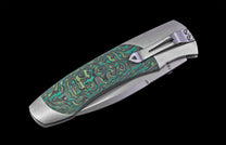 Foldable knife with green patterned handle on a black background
