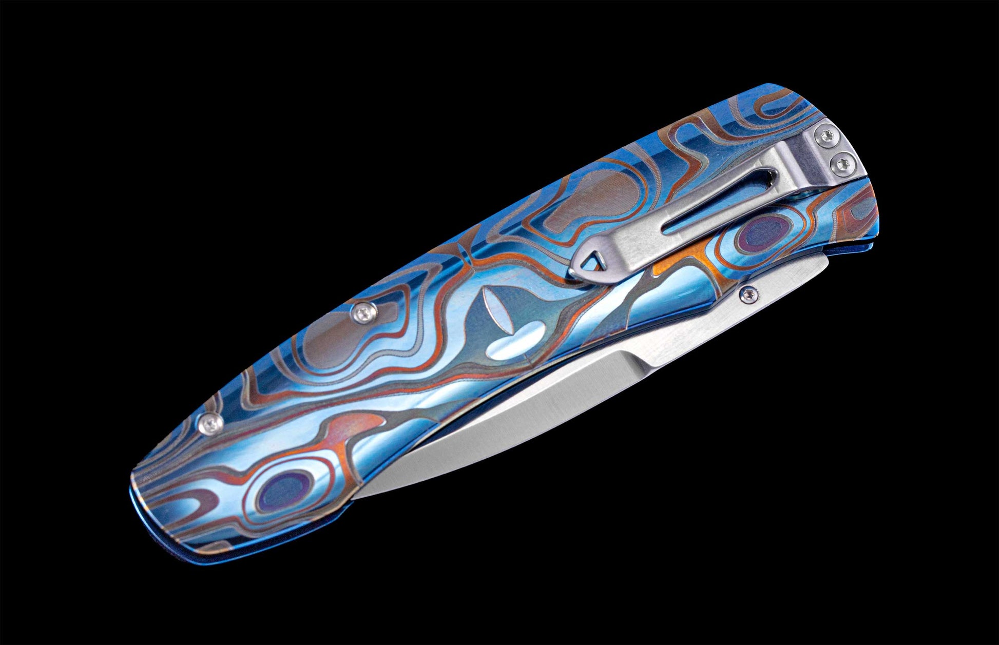 Folding knife with anodized and color-laser engraved frame on a black background