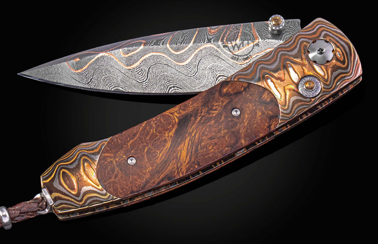 Folding knife with decorative handle and blade on a black background