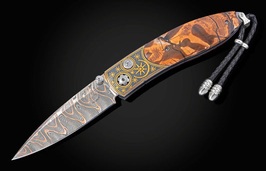 Folding knife with inlaid gold designs and mammoth tusk handle on a black background with blade open
