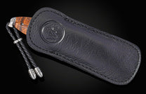 Black leather sheath with knife on a black background