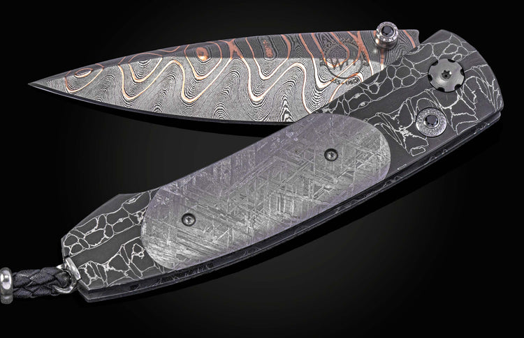 William Henry folding knife with Damascus steel blade  and frame with  Gibeon meteorite scales on a black background