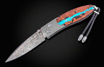 William Henry knife inlaid with vein turquoise and lava rock with damascus blade.