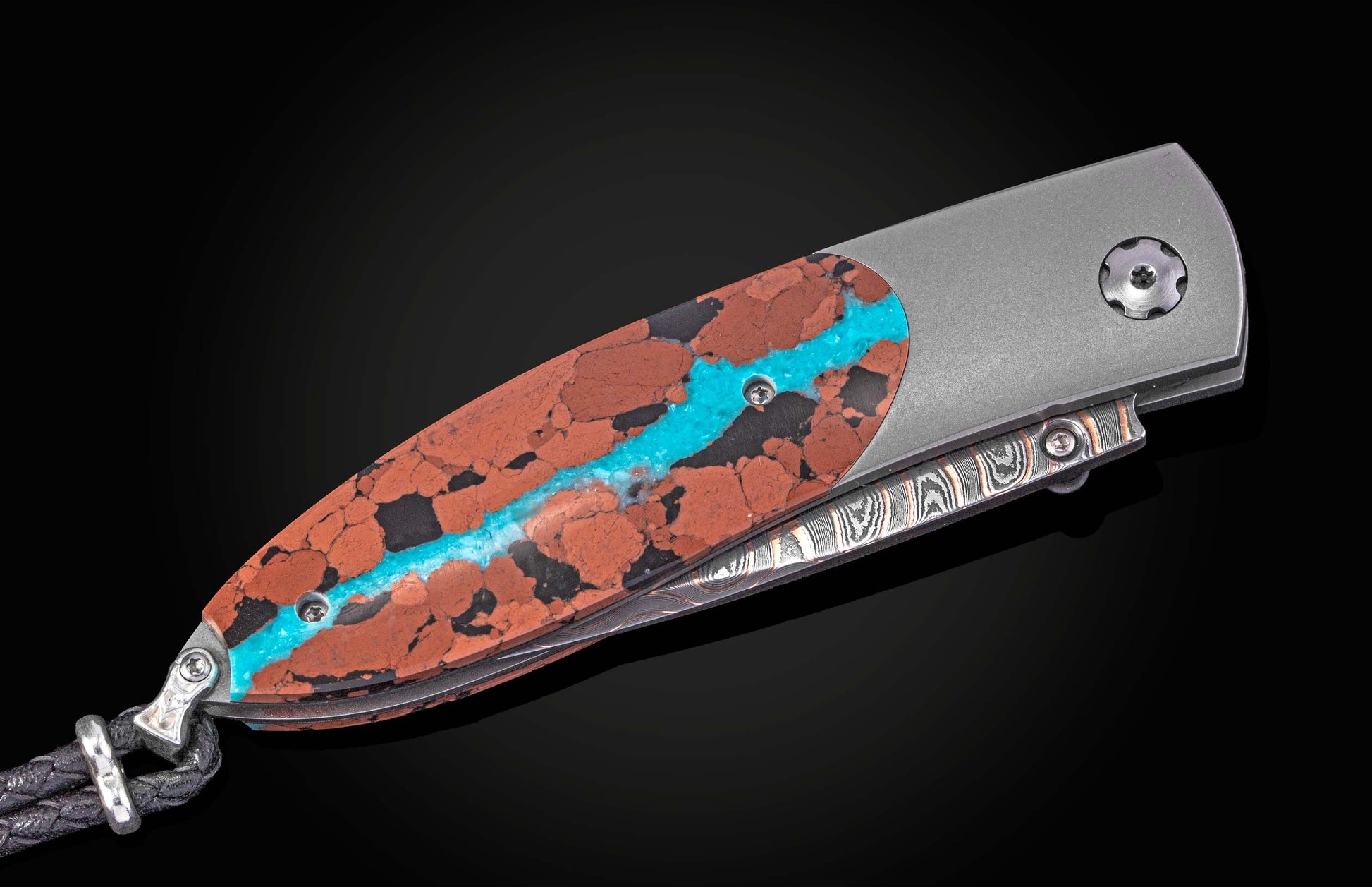 William Henry knife inlaid with vein turquoise and lava rock with damascus blade.