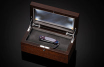 William Henry knife with a colorful handle and engraved blade on a black background