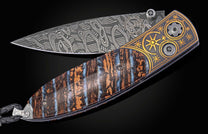 Decorative knife with a fossil mammoth tooth and gold handle on a black background displayed partially open