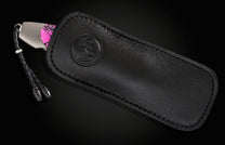 Luxury black leather knife sheath with embossed logo, featuring a silver-toned blade and vibrant pink camo handle, shown in side view.