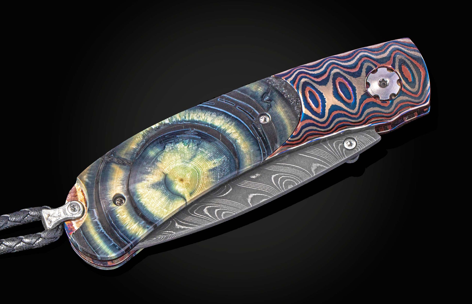 Folding knife with Wave Mokume, fossil mammoth tusk, and a damascus blade on a black background