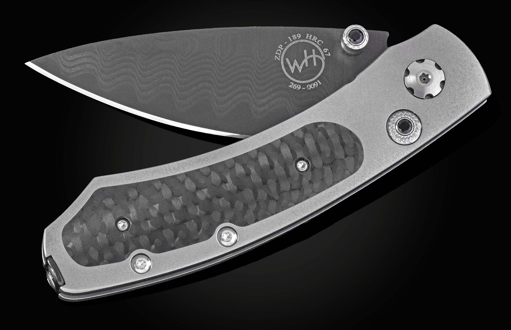 Dark gray folding knife with a wavy pattern blade and metallic gray handle with textured carbon fiber inserts.