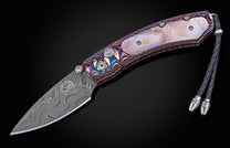 Folding knife with decorative handle on a black background