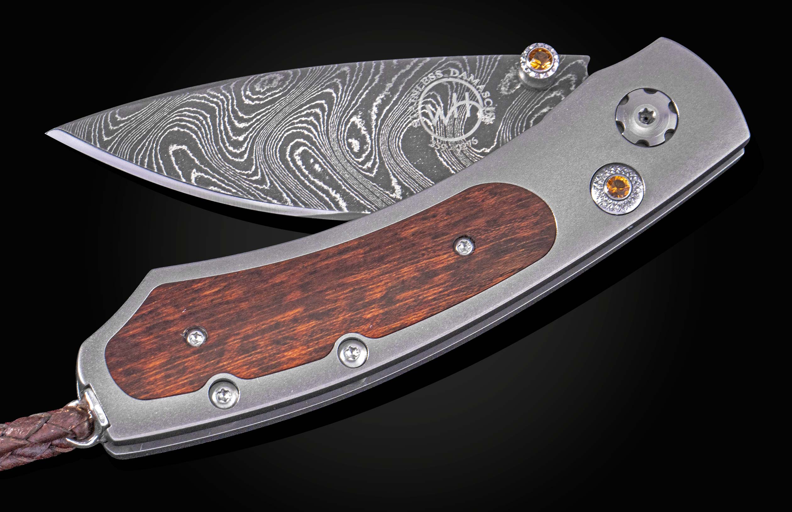 Folding knife with wooden handle and damascus blade on a black background