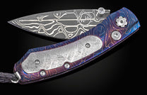 Folding knife with decorative handle and blade on a black background
