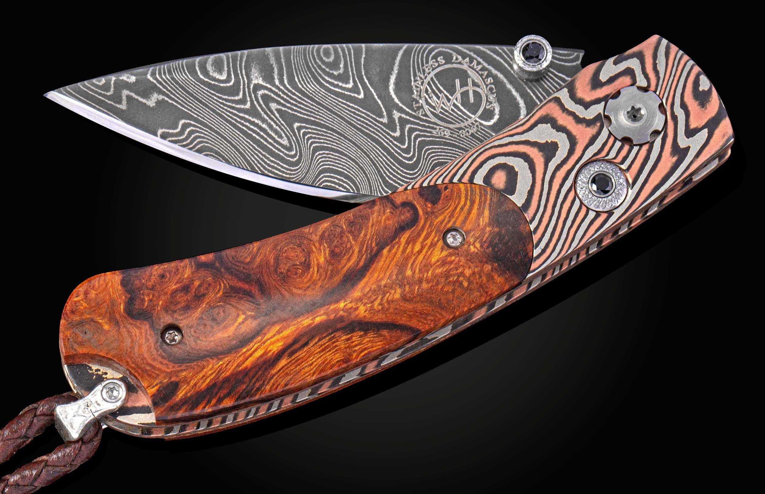 Folding knife with a decorative blade and desert ironwood handle on a black background with the blade part way open