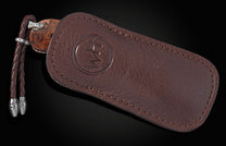 Brown leather case with a knife on a black background