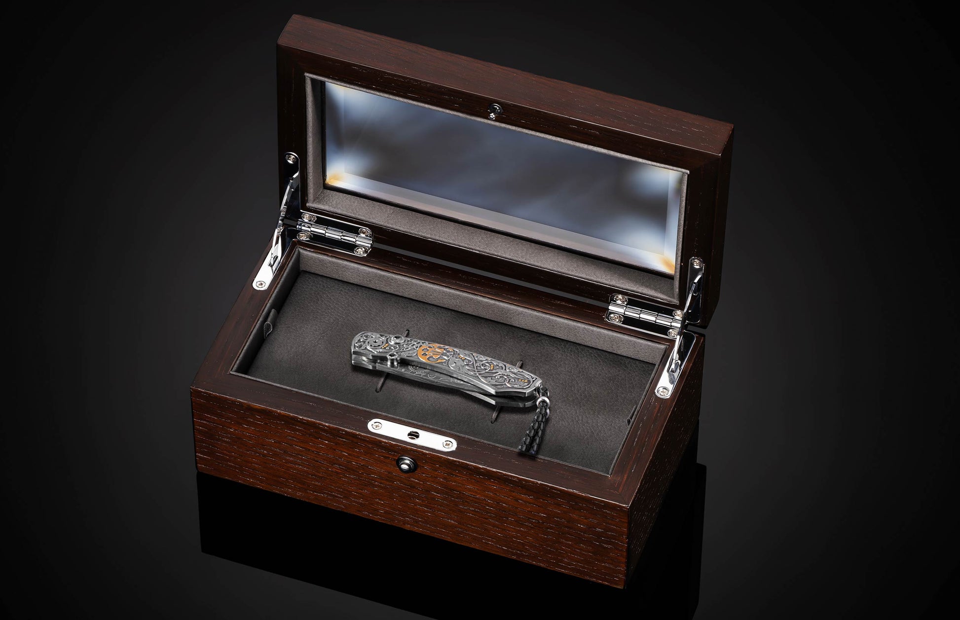 Decorative knife with intricate patterns in a wooden case on a dark background