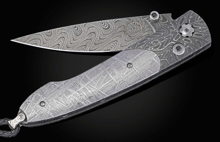 Decorative knife with damascus blade and meteorite handle on a black background partially open
