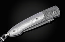 Decorative knife with damascus blade and meteorite handle on a black background shown closed