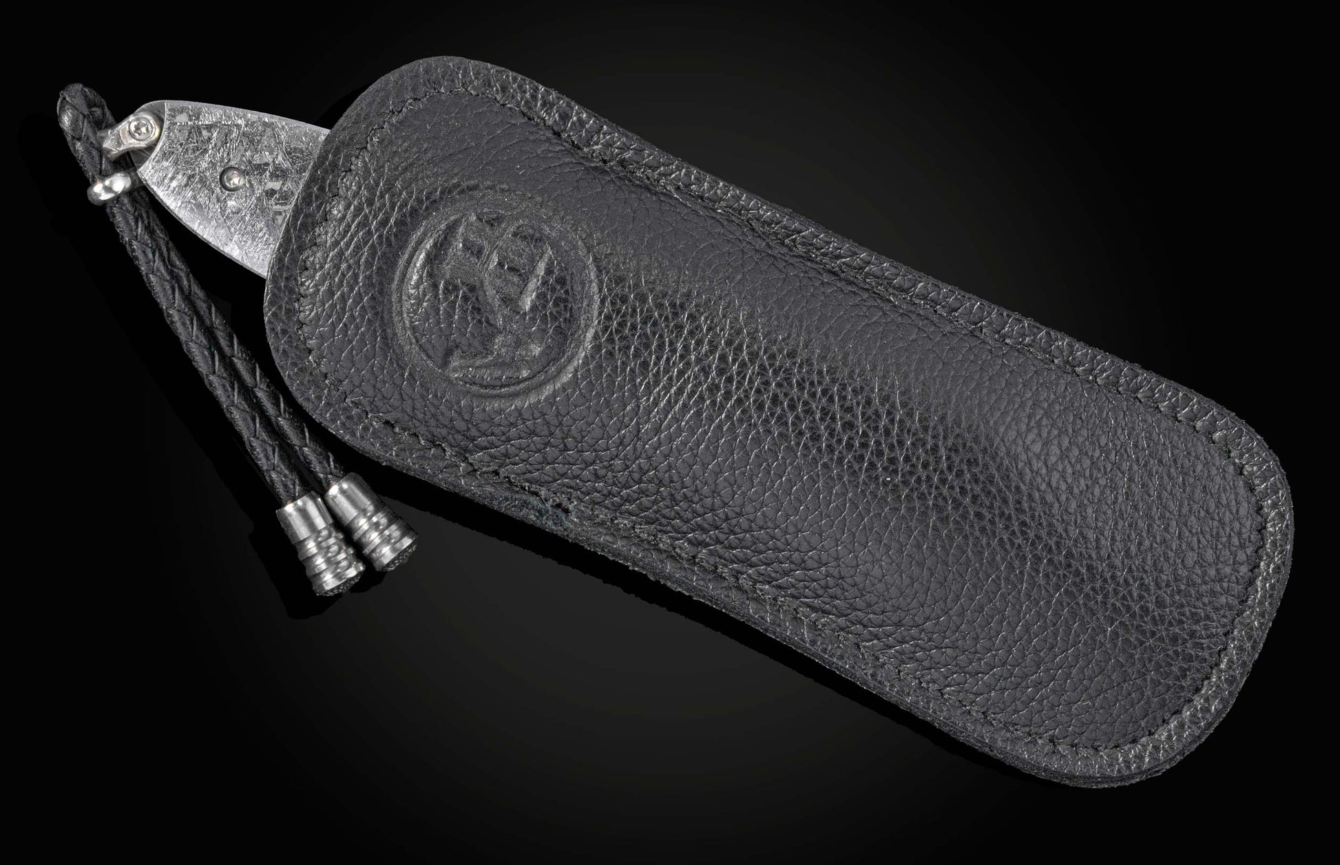 Black leather sheath with a knife on a black background