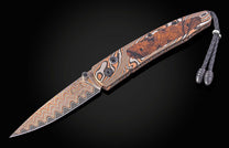 Damascus steel folding knife with wavy pattern and wood-inlay handle, by B10 Riverwood, featuring braided lanyard and polished hardware, side view on black background