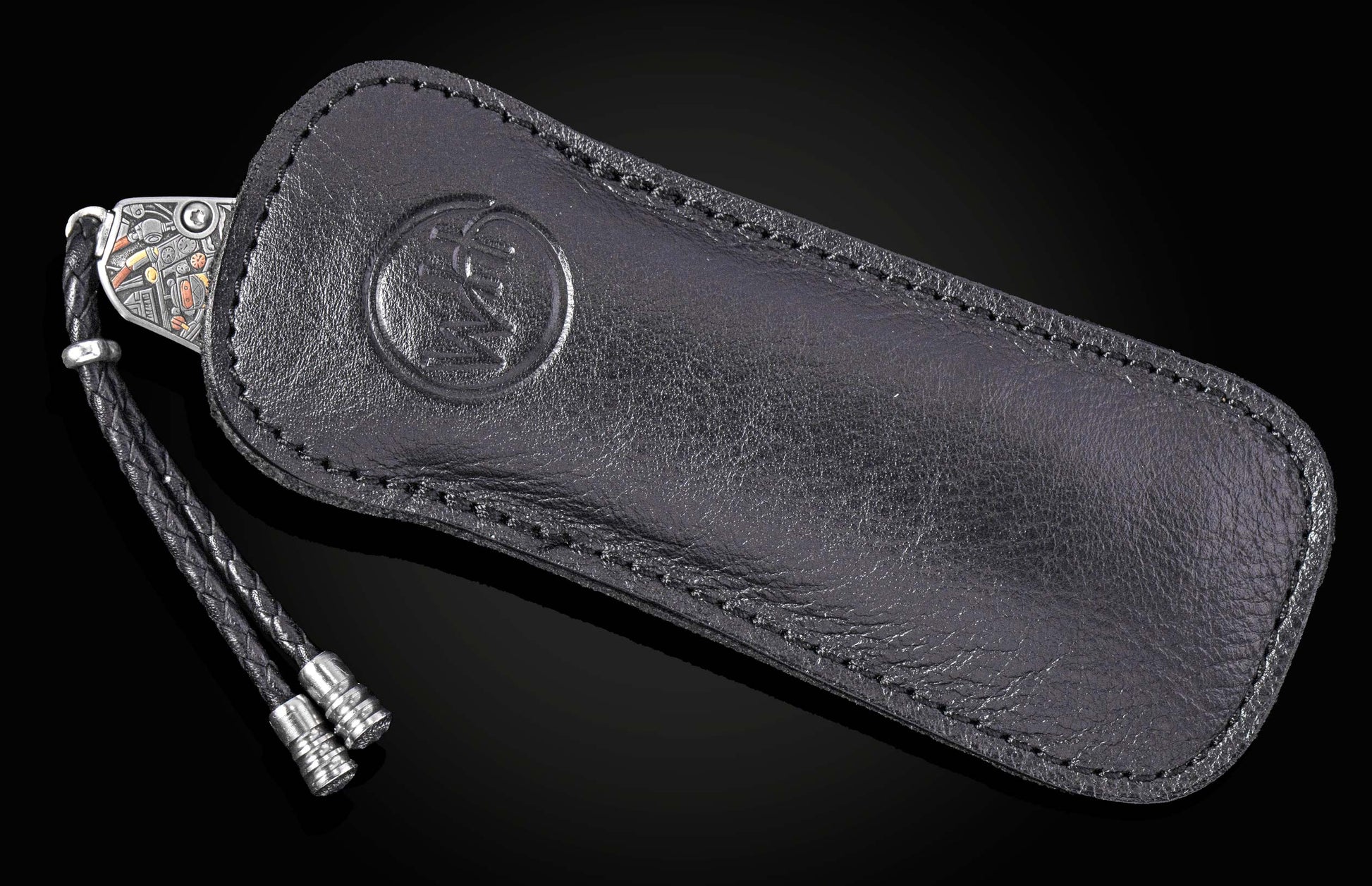 Black leather knife sheath with embossed logo and braided cord, by B12, featuring detailed silver hardware and precise stitching, side view.