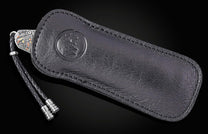 Black leather knife sheath with embossed logo and braided cord, by B12, featuring detailed silver hardware and precise stitching, side view.