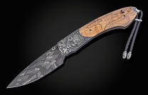 Folding knife with wooden handle and decorative blade on a black background