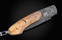 Folding knife with wooden handle and decorative blade on a black background