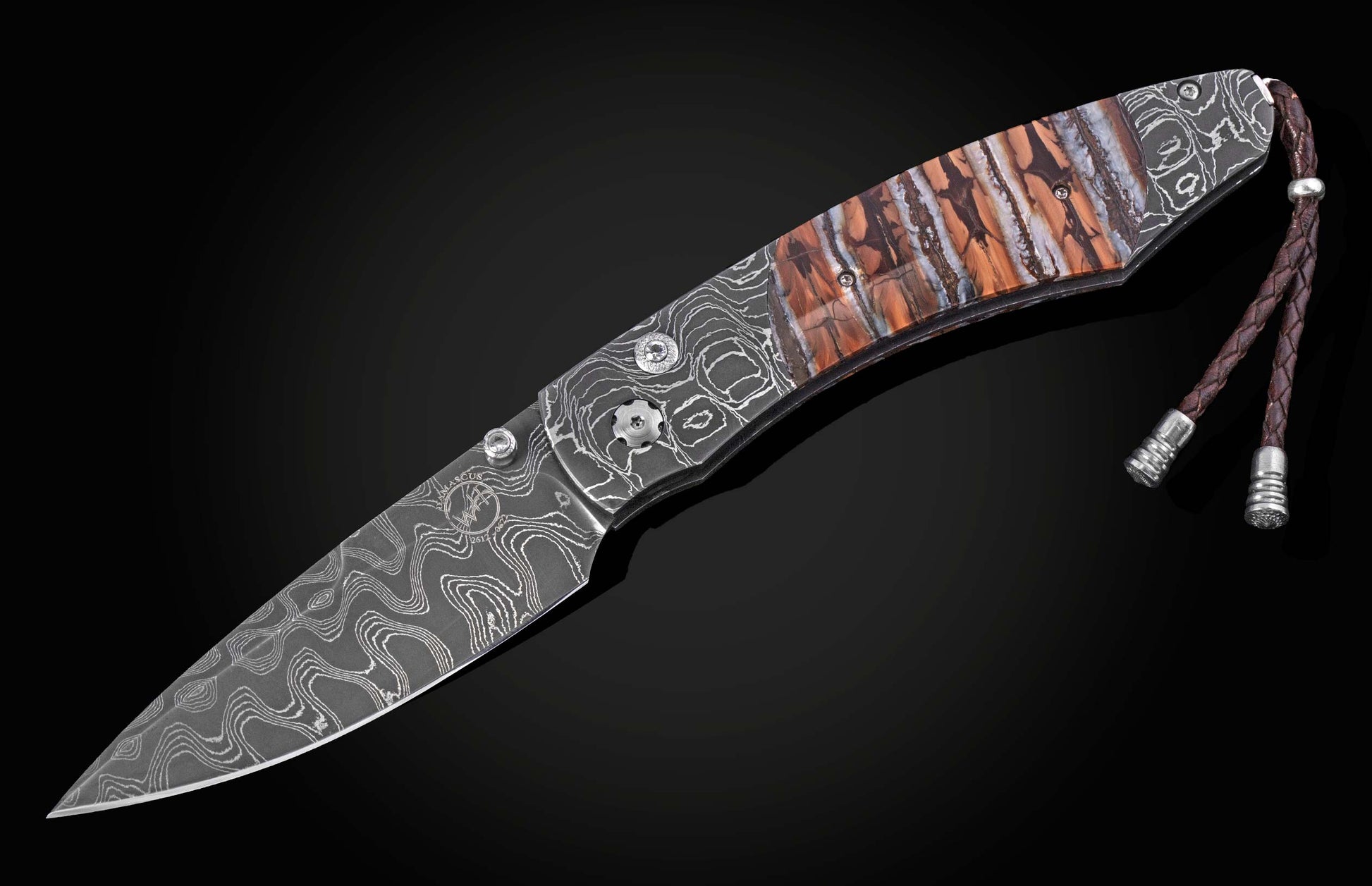 Folding knife with a Damascus steel blade and patterned handle featuring orange, brown, and white scales, with a braided brown leather lanyard.